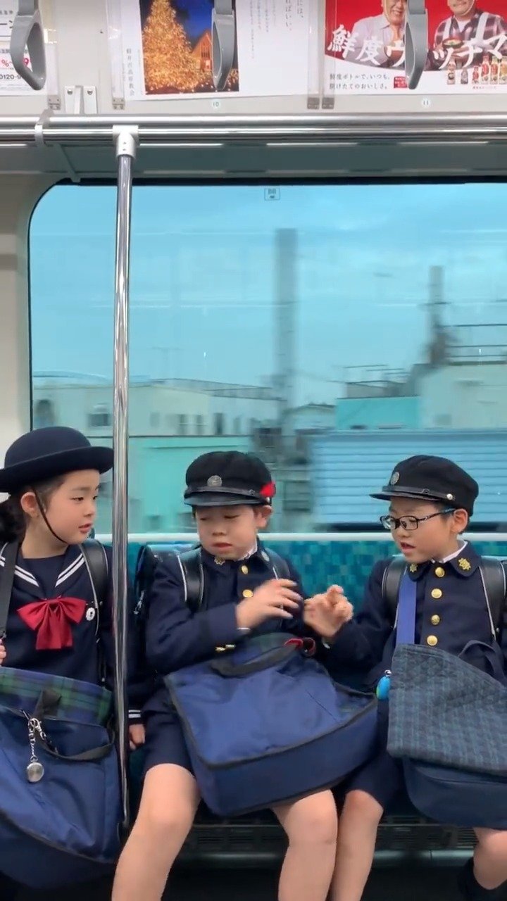 日本东京,在地铁上玩耍的三个小朋友,好可爱