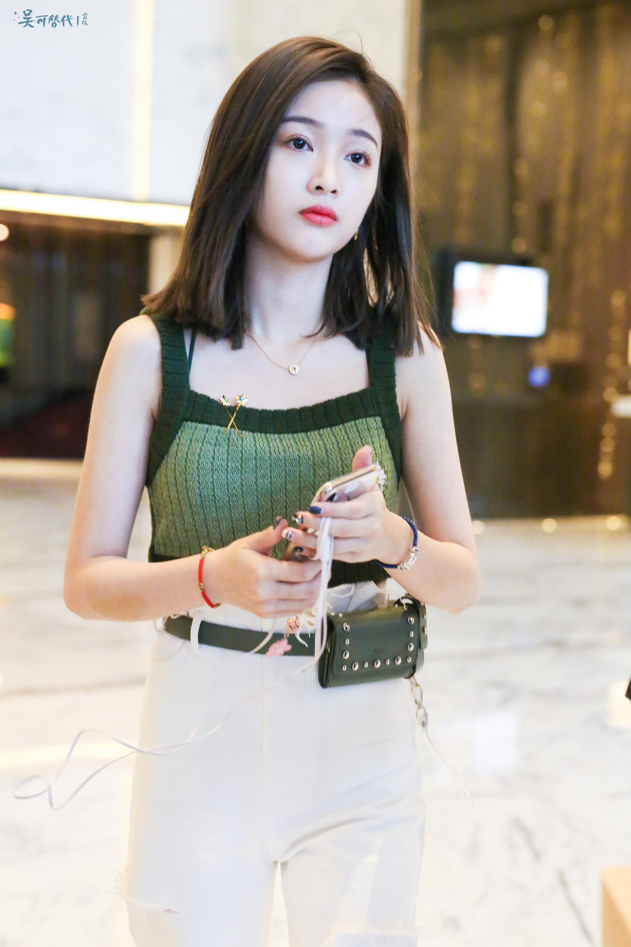 吴宣仪上海机场出发北京齐肩短发绿色吊带白色休闲裤