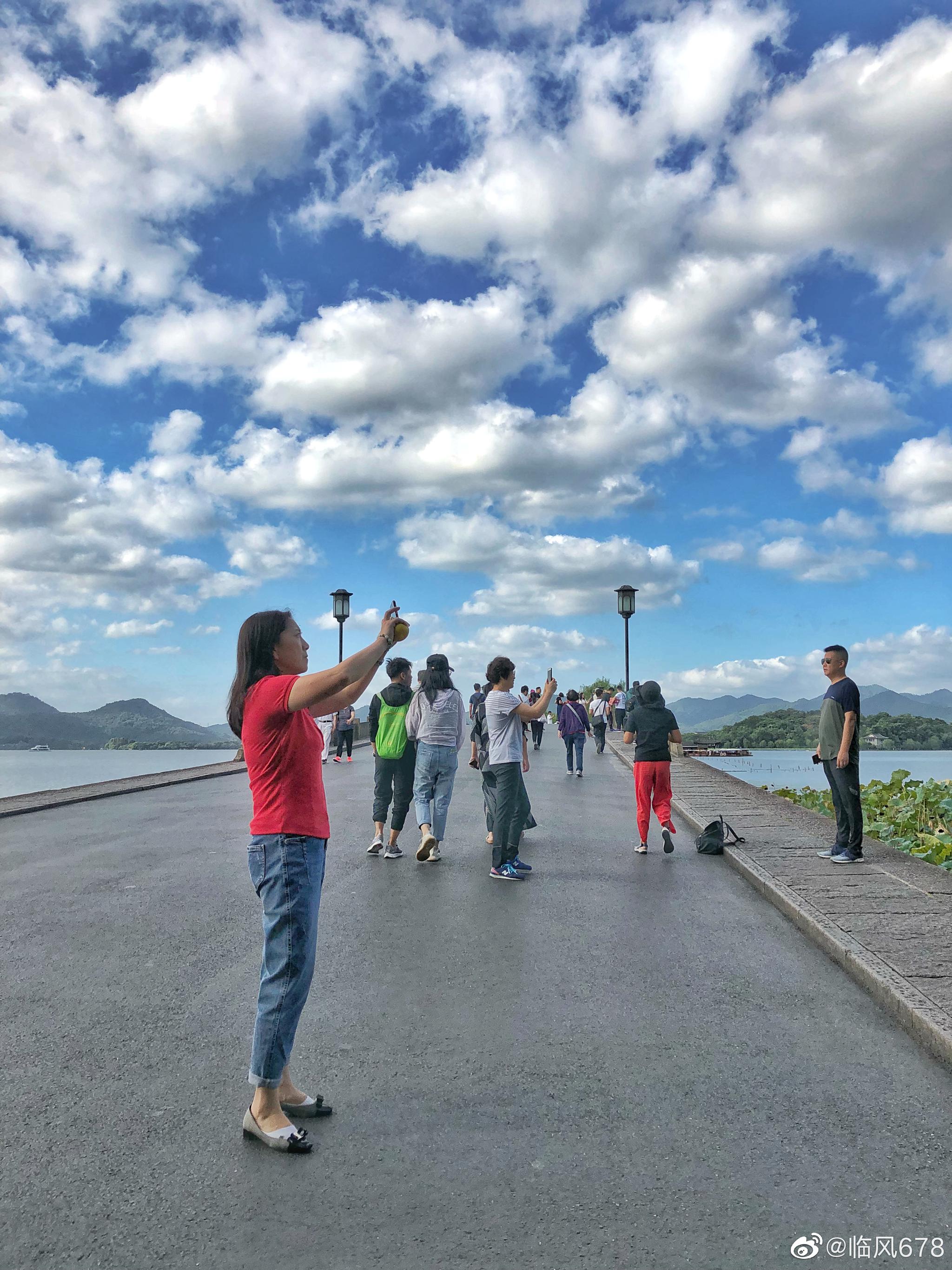 九月的天空,蓝天白云下的西湖,早上己经很多人在跑步拍照了.