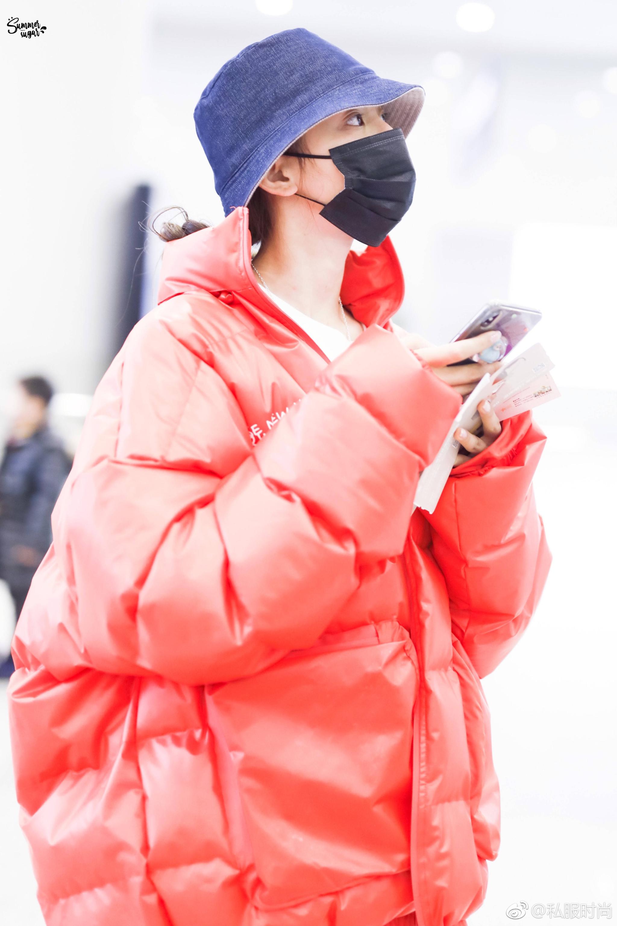 2月7日@火箭少女101_杨超越 现身机场,身着橘红色羽绒服搭配牛仔裤