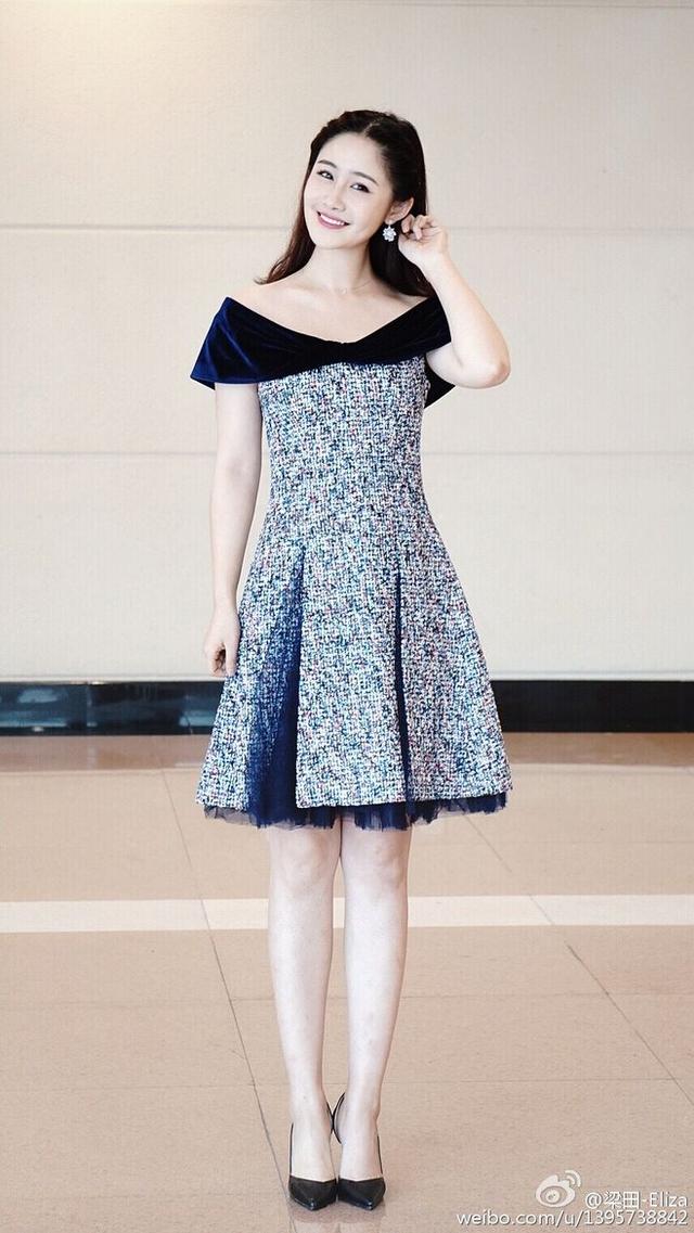 梁田穿着一件黑色和花色相拼接的裙子,脚上穿着一双黑色的高跟鞋,耳朵