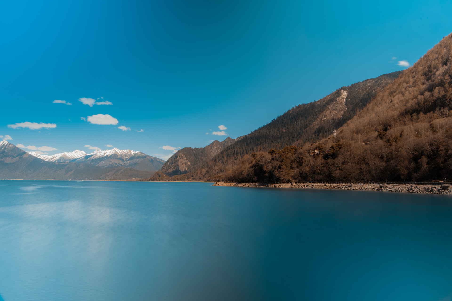 巴松措,四周的雪山其中环绕,湖中有一个小岛叫扎西