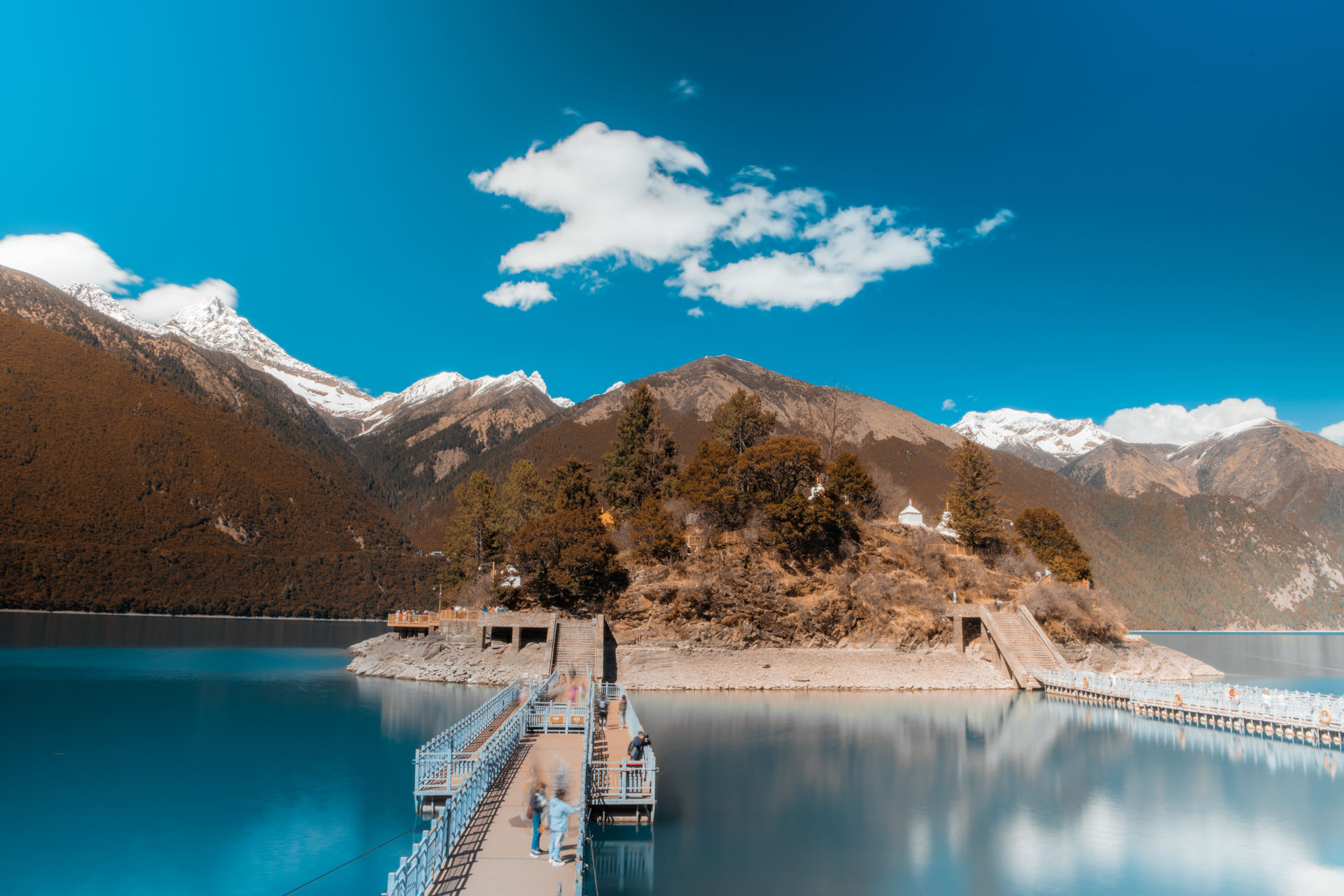 巴松措,四周的雪山其中环绕,湖中有一个小岛叫扎西岛