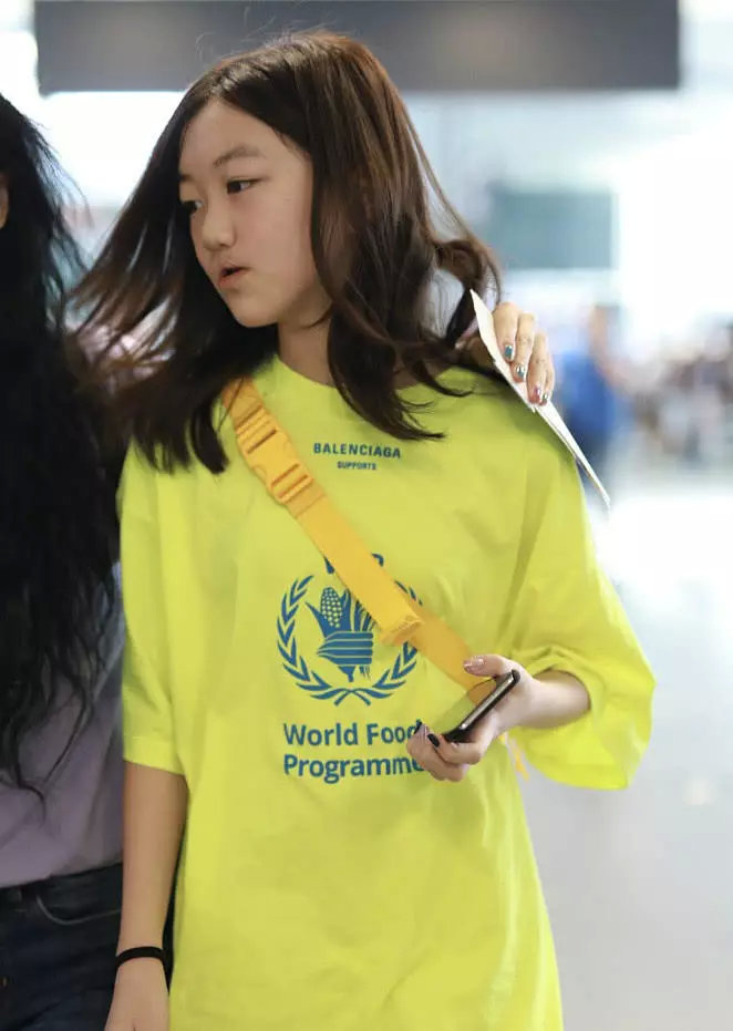 李嫣身穿荧光绿t恤现身机场 玩下衣失踪秀长腿一路玩手机
