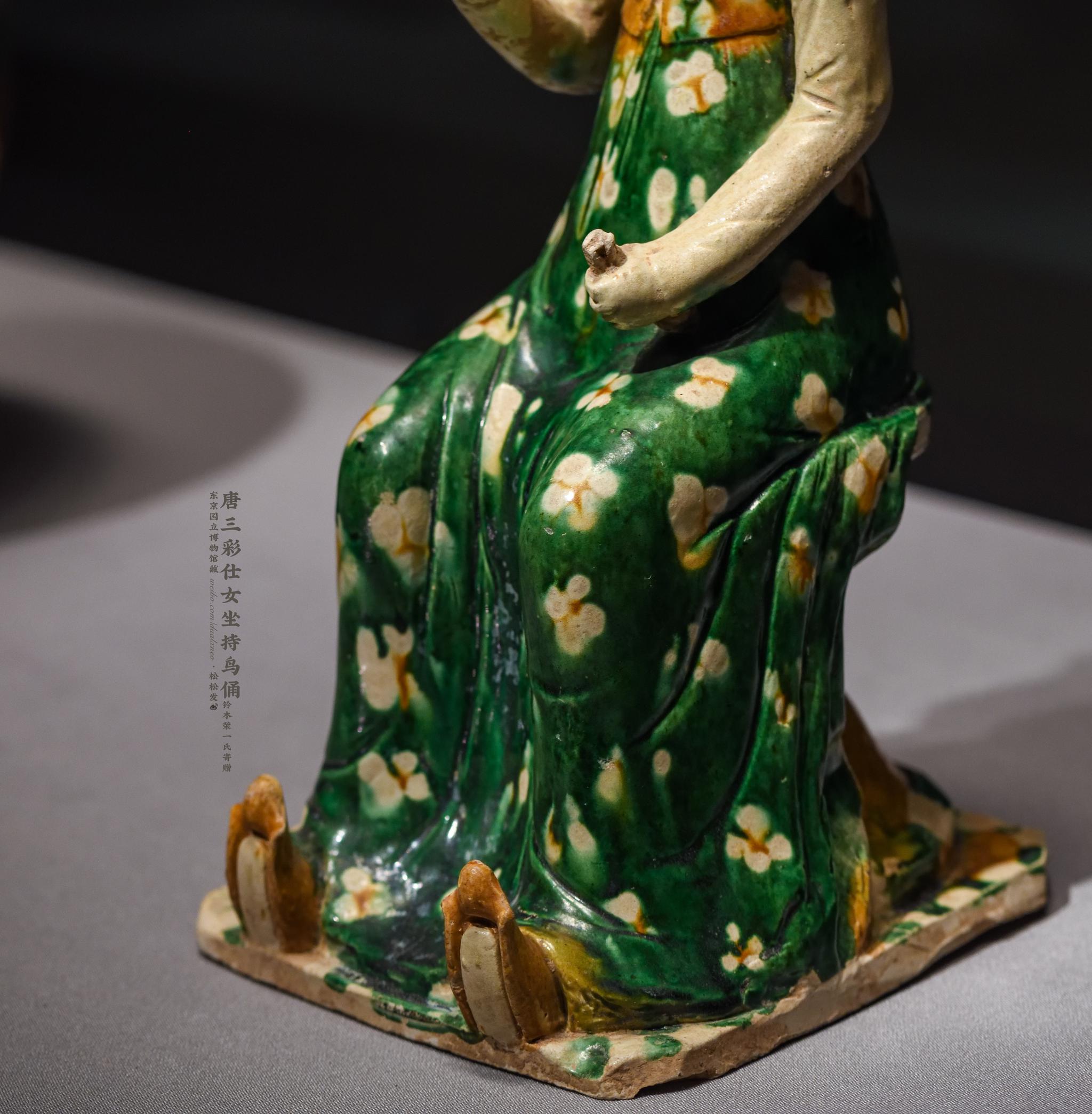 的女子倚坐筌蹄持鸟俑,造型上接近西安王家坟90号墓出土的唐三彩女俑