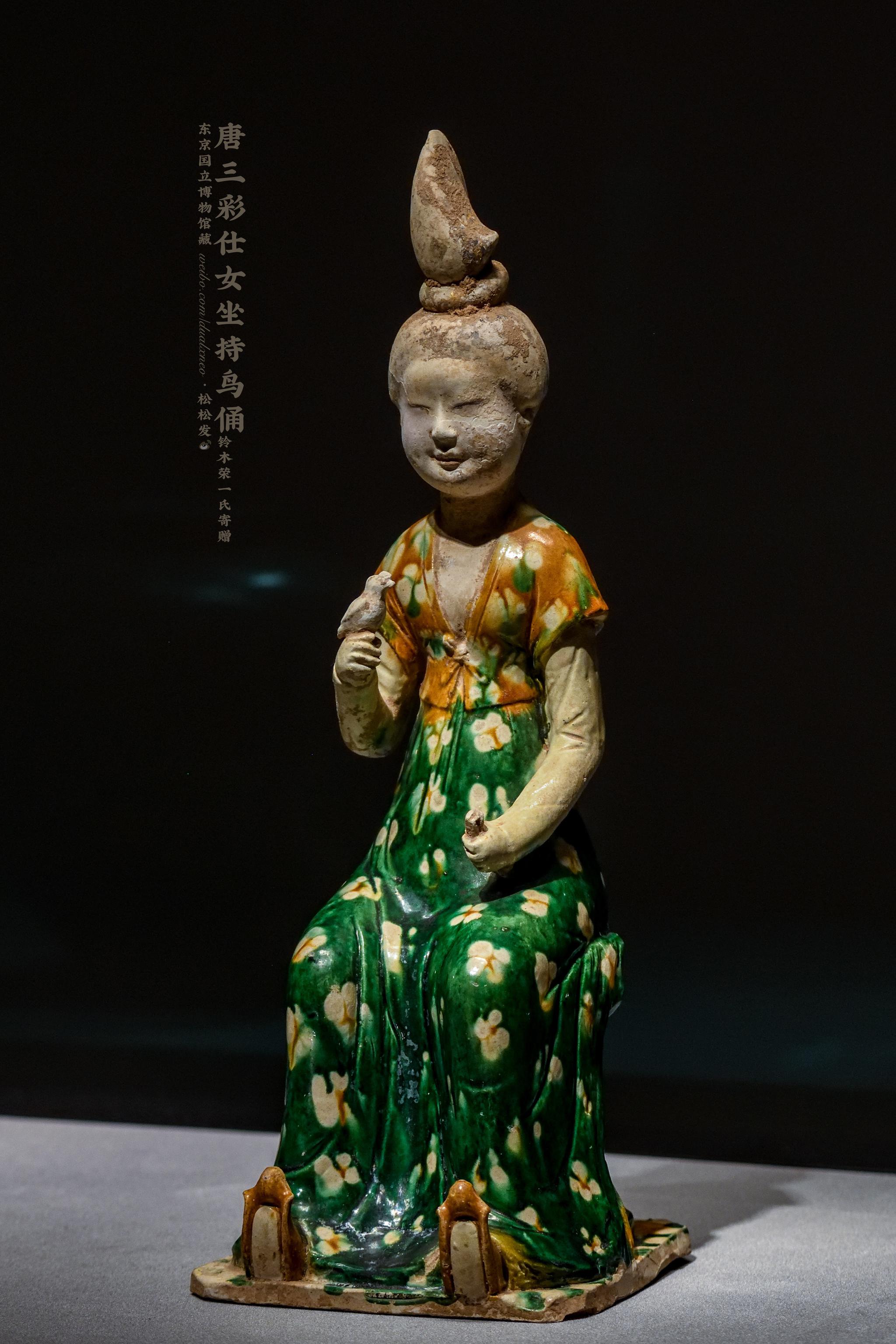的女子倚坐筌蹄持鸟俑,造型上接近西安王家坟90号墓出土的唐三彩女俑