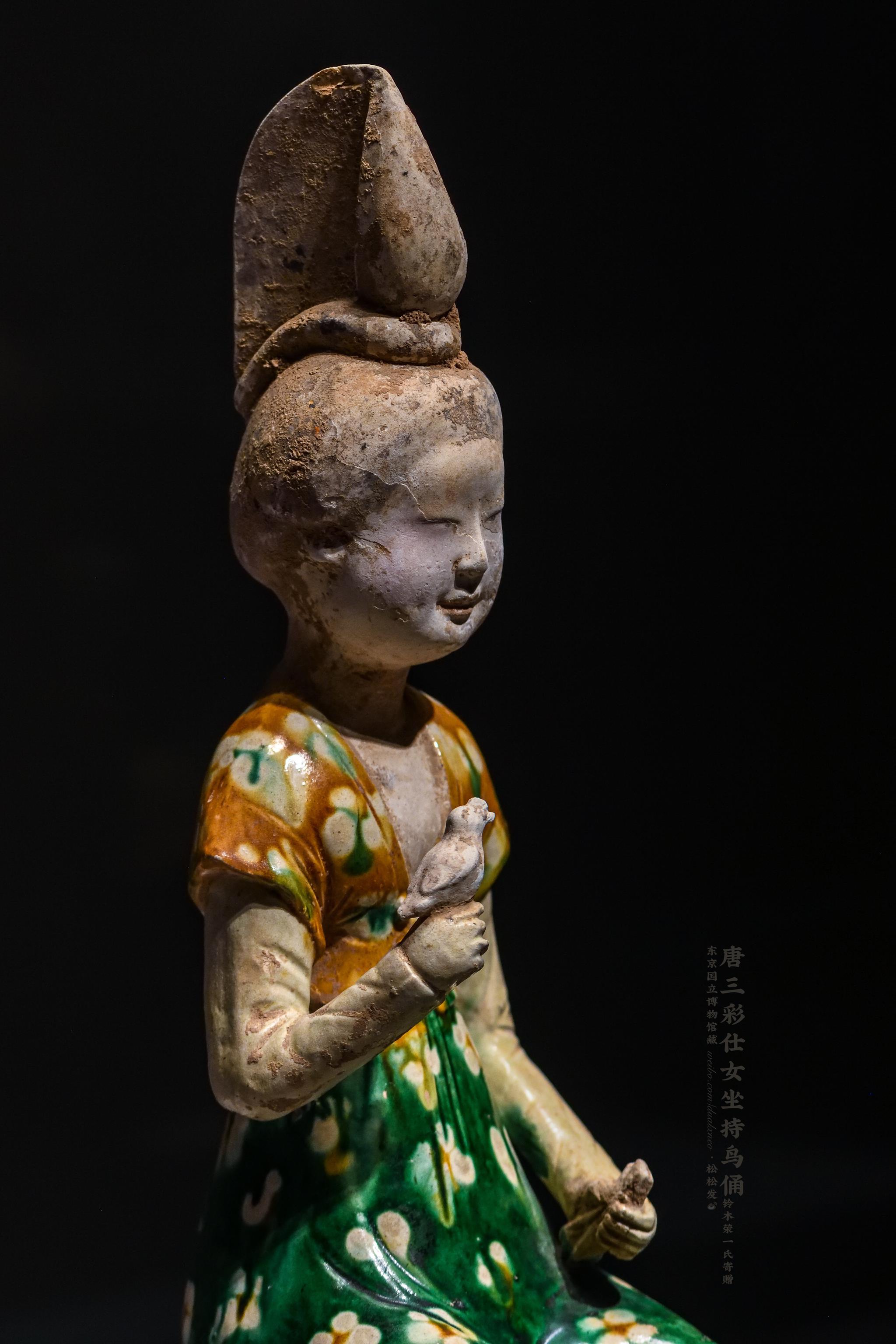 的女子倚坐筌蹄持鸟俑,造型上接近西安王家坟90号墓出土的唐三彩女俑