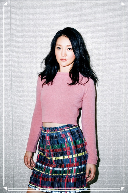 粉色的毛衣搭配上了一条花哨的半身裙,这件上衣是露脐的款式,穿在周迅