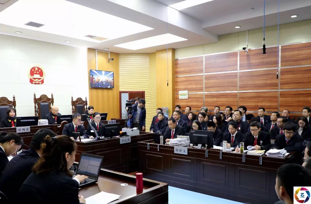 套路贷集团受审,被告席和律师席黑压压一片,5民警成"保护伞"