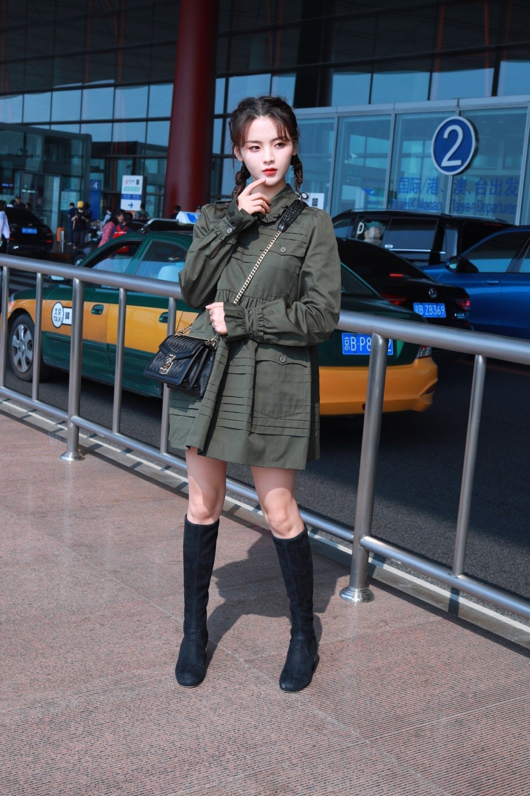 杨超越身穿军绿色衬衫裙搭配及膝长筒靴加羊角辫,赶赴巴黎时装周