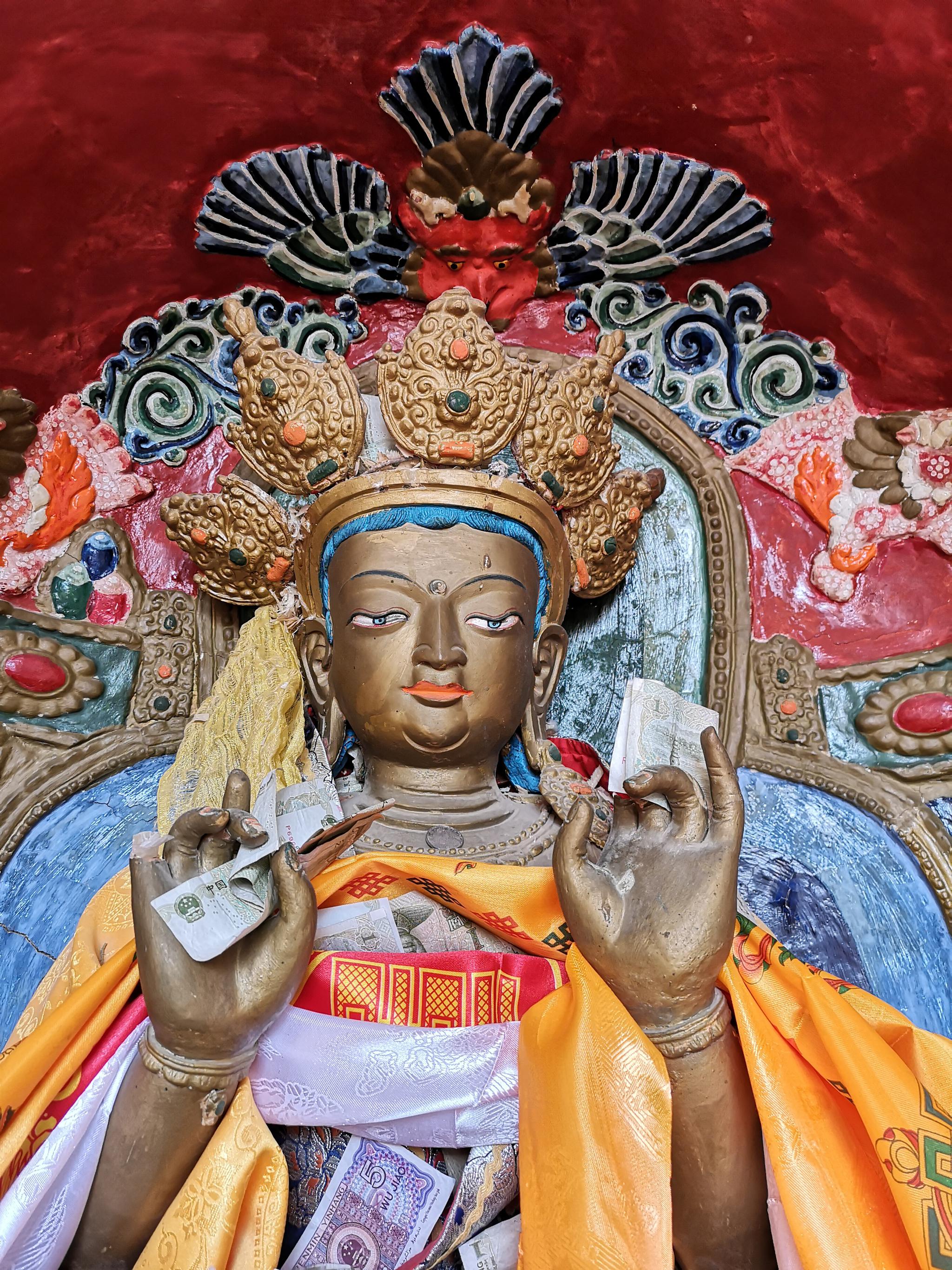 张掖马蹄寺石窟,游客塞在佛像手上的钱