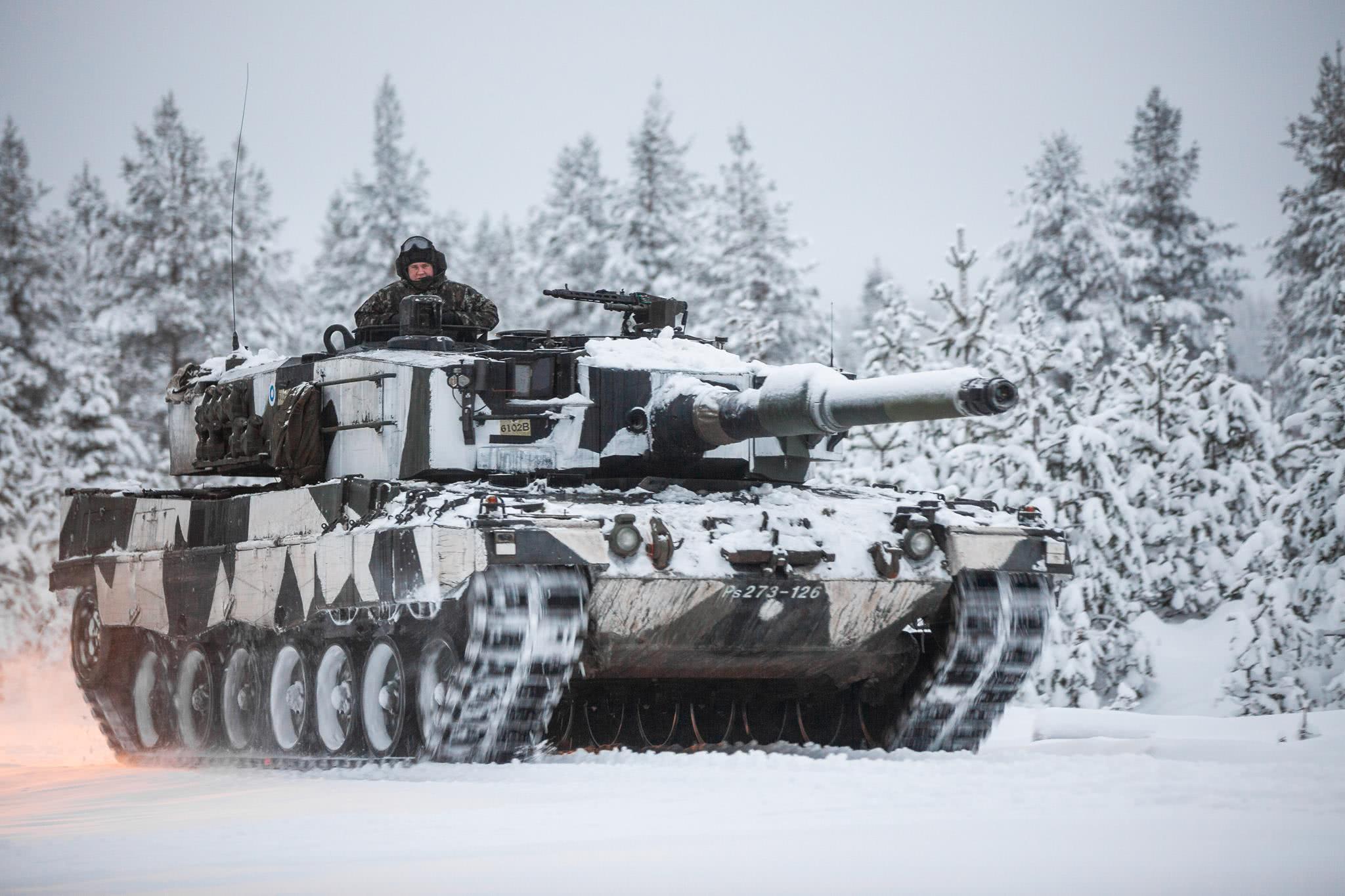 抹上了雪地伪装的"豹2"主战坦克在雪原突击