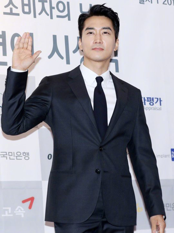 宋承宪身穿黑色西装搭配同色西裤,内搭白色衬衫,领口系着黑色领带英俊