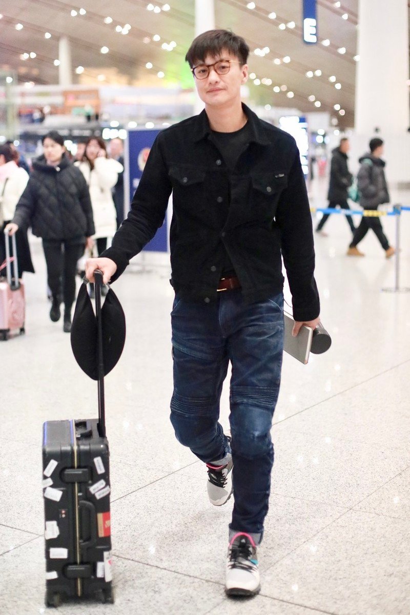 周一围手握保温杯走机场,戴镜框装"嫩",一低头暴露双下巴