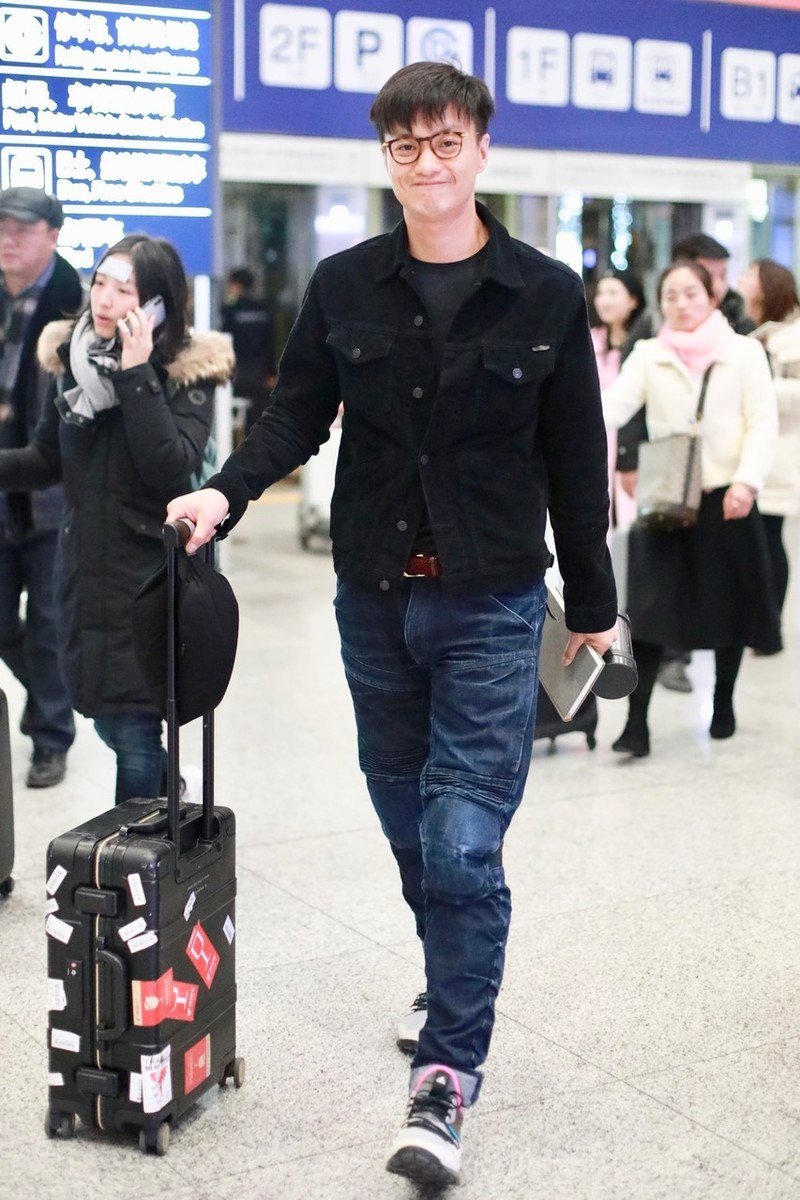 周一围手握保温杯走机场,戴镜框装"嫩",一低头暴露双下巴