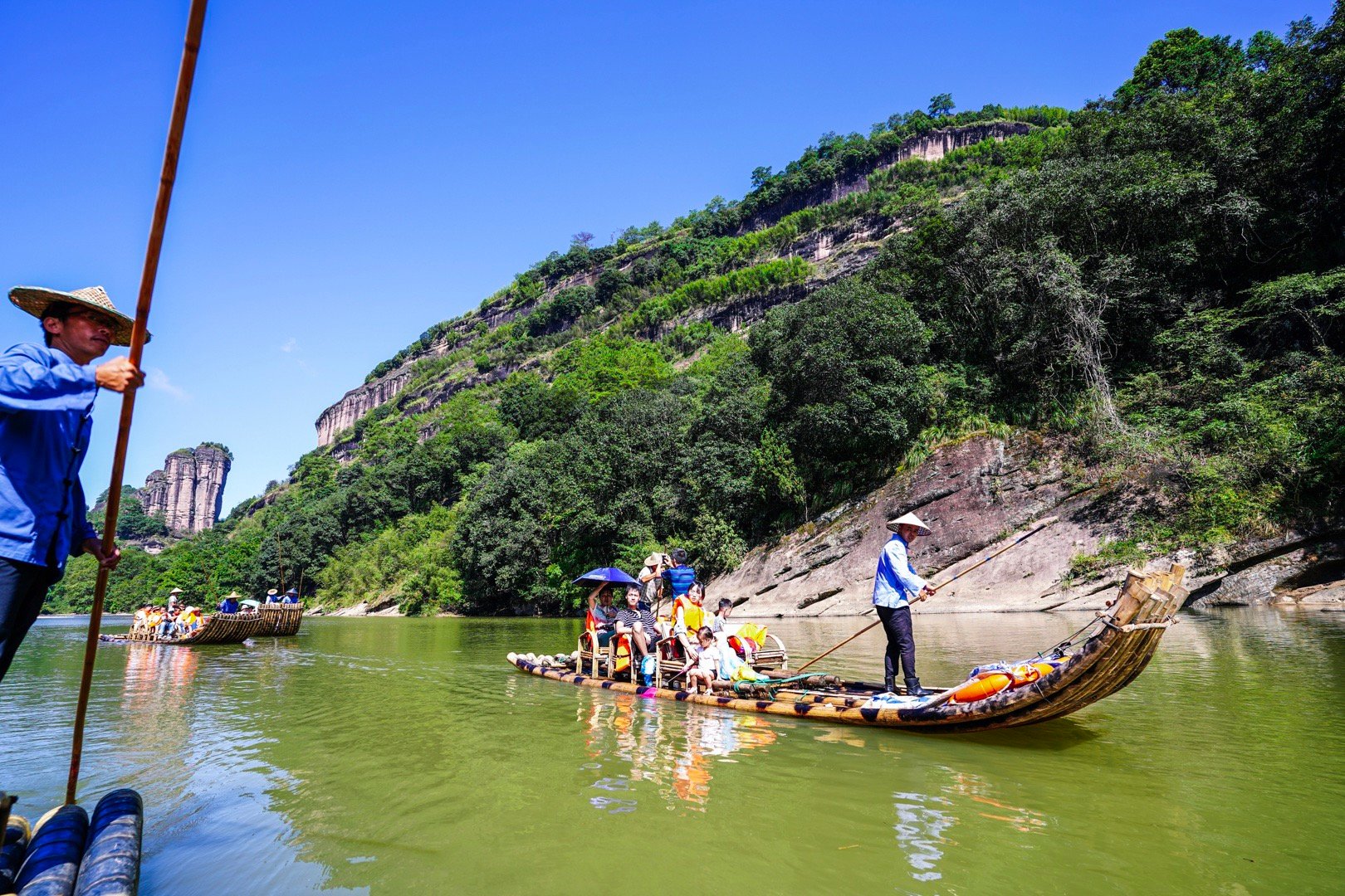 在武夷山体验九曲溪漂流,乘坐竹筏荡入水光山色之中