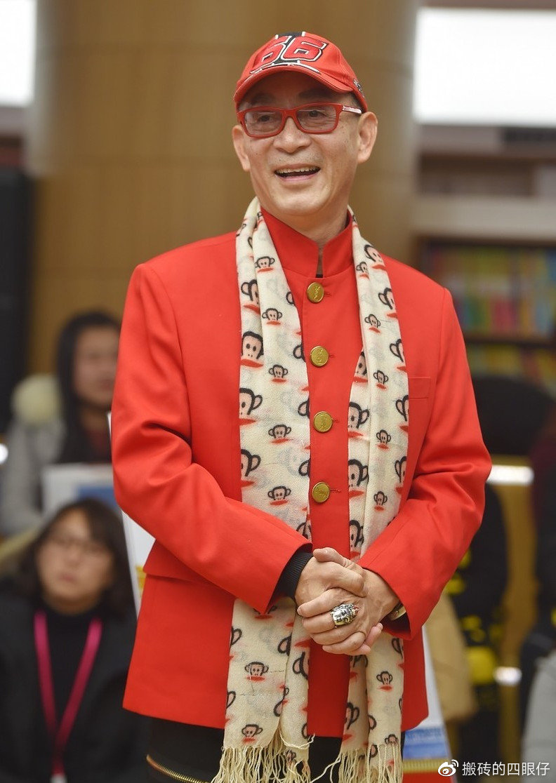 六小龄童现身机场,棒球服叠穿大衣配丝巾,60岁却偏爱红色