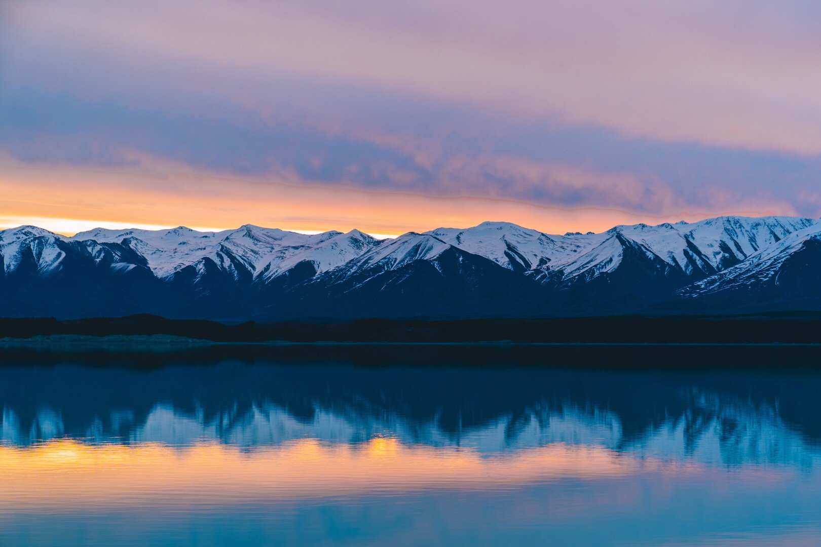 傍晚的普卡基湖有些宁静湖面倒映着橙黄色的夕阳余晖这或许是新西