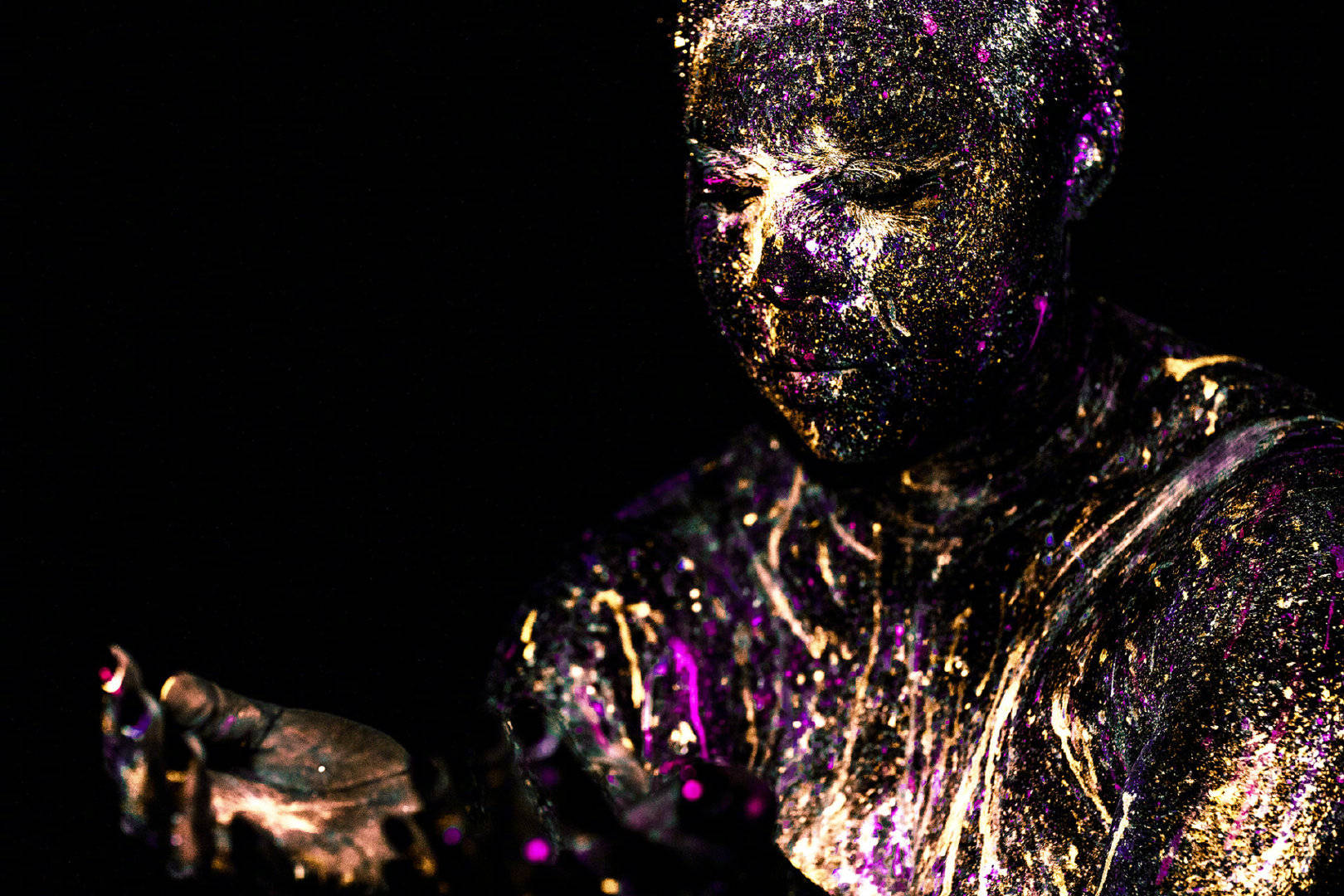 由荧光颜料彩绘的人体模特完全融入纯黑的背景