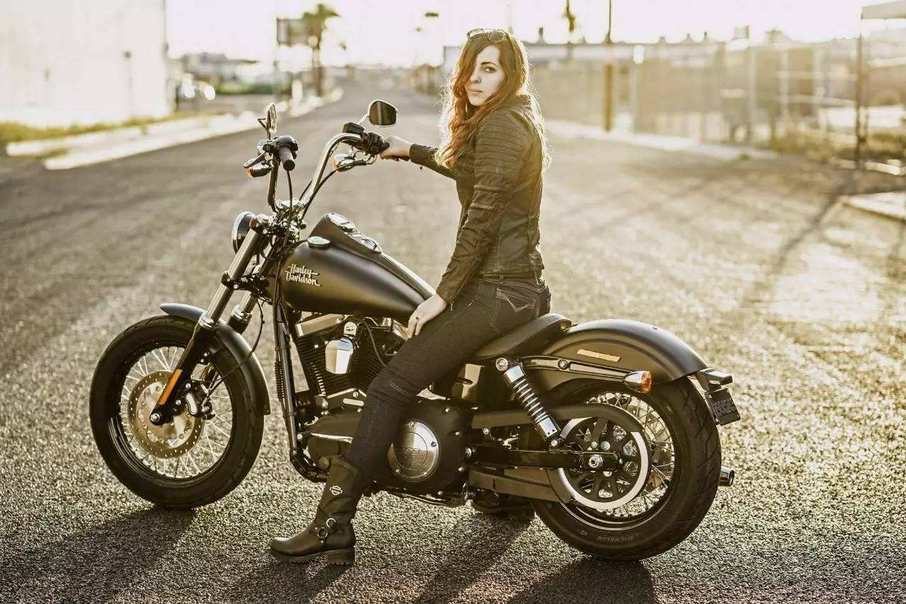 女人一脚踩着摩托车图片