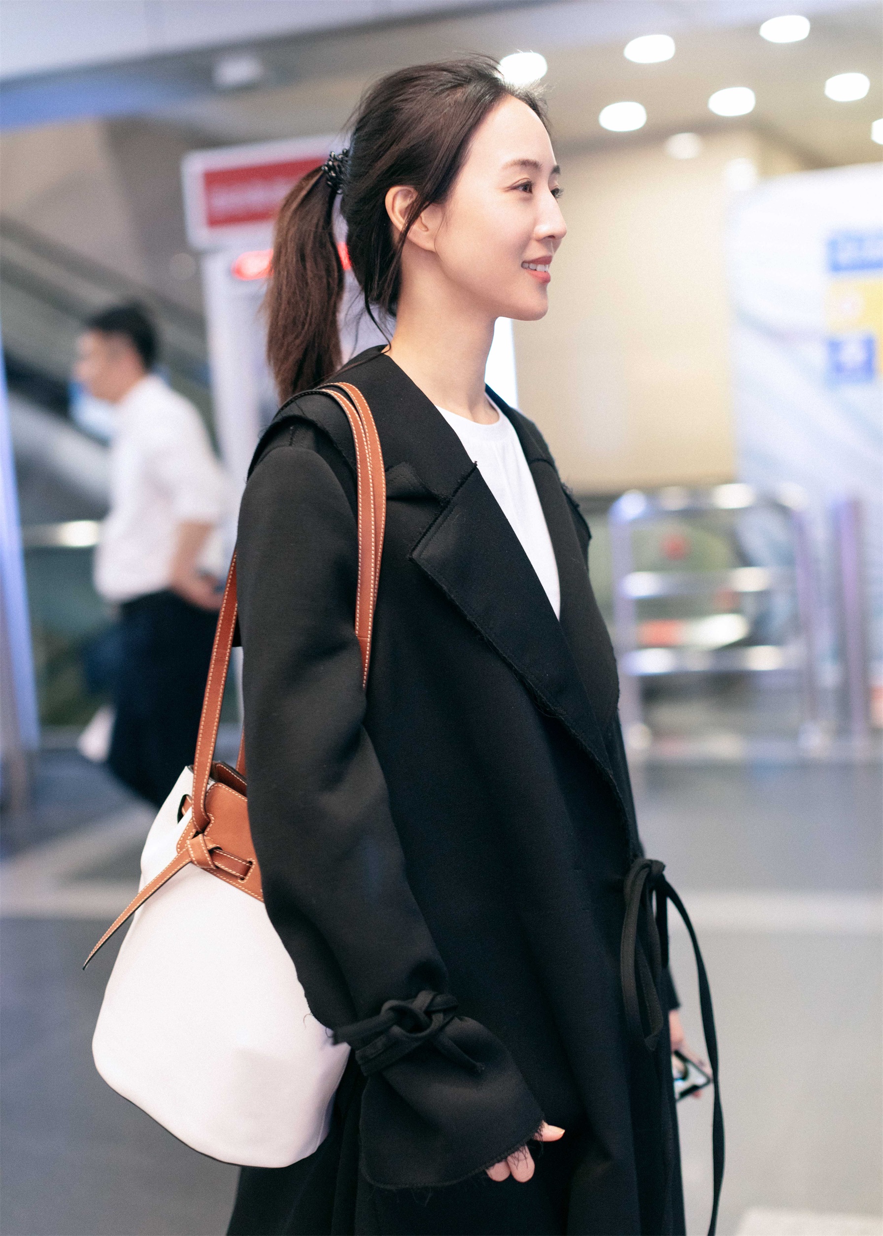 张钧甯 机场照曝光,一身黑色腰带式秋千外套搭配黑色长靴酷范十足