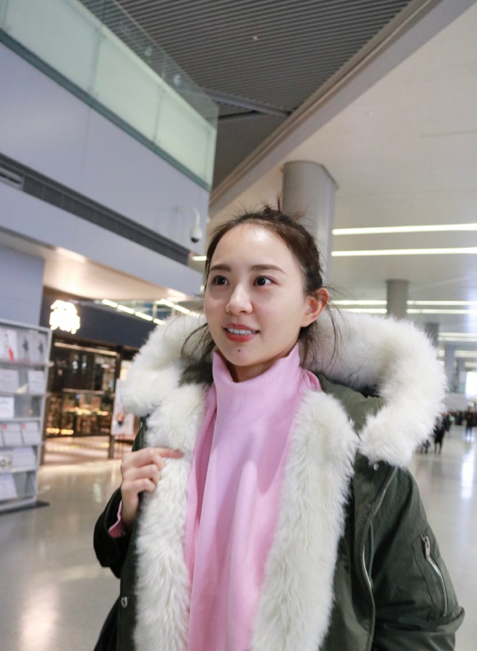 清新气质的甜笑少女孙耀琦扎着丸子头挎着黑色包包遛机场