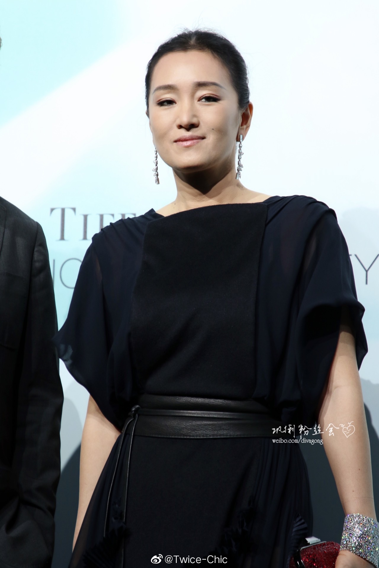 巩俐今日身着木耳边黑色礼服现身上海出席时尚活动