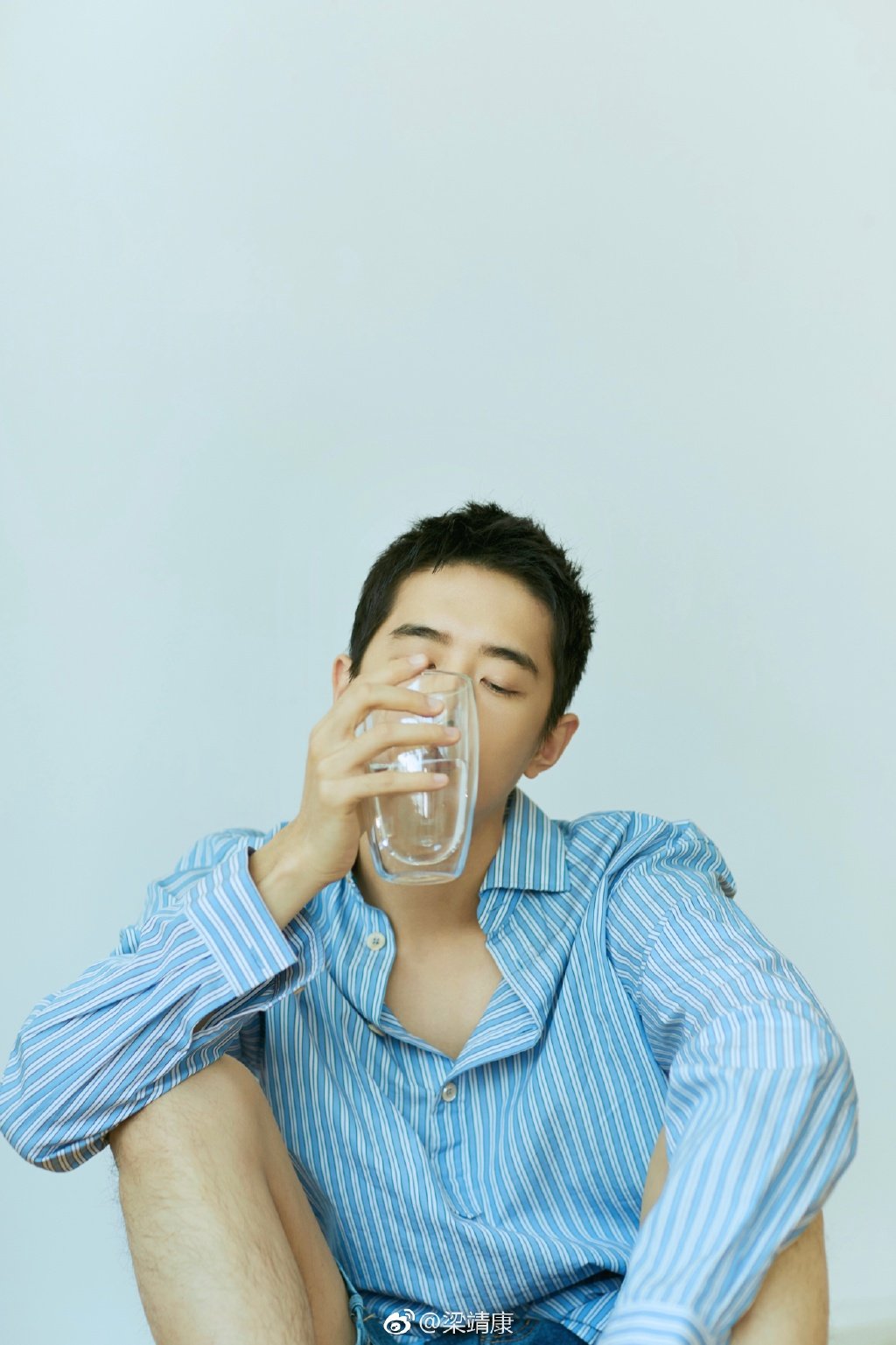 梁靖康身着蓝色条纹衬衫搭配牛仔短裤,清爽有型,随性自在