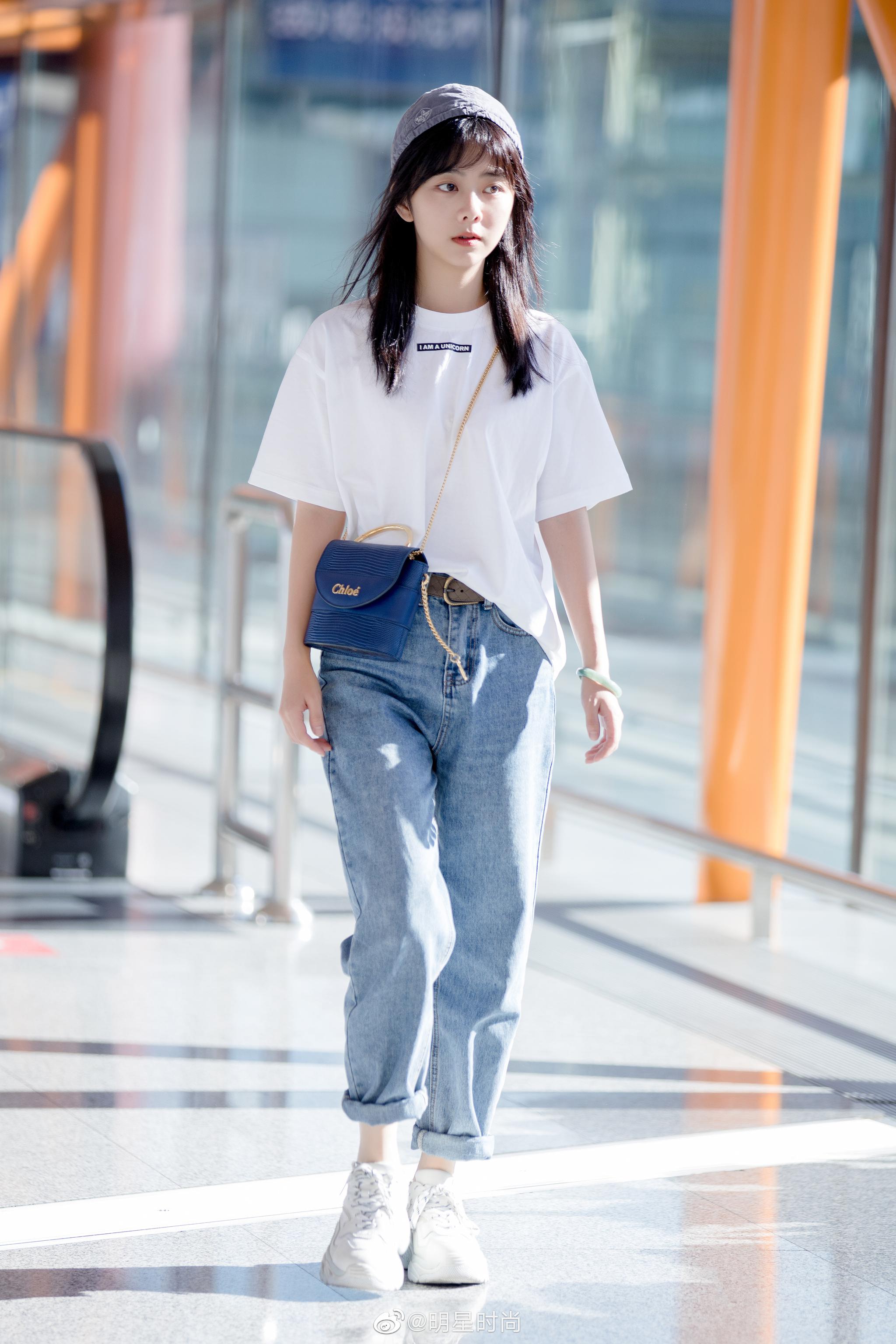 8月27日,谭松韵现身北京机场,burberry白t搭配卷边牛仔裤