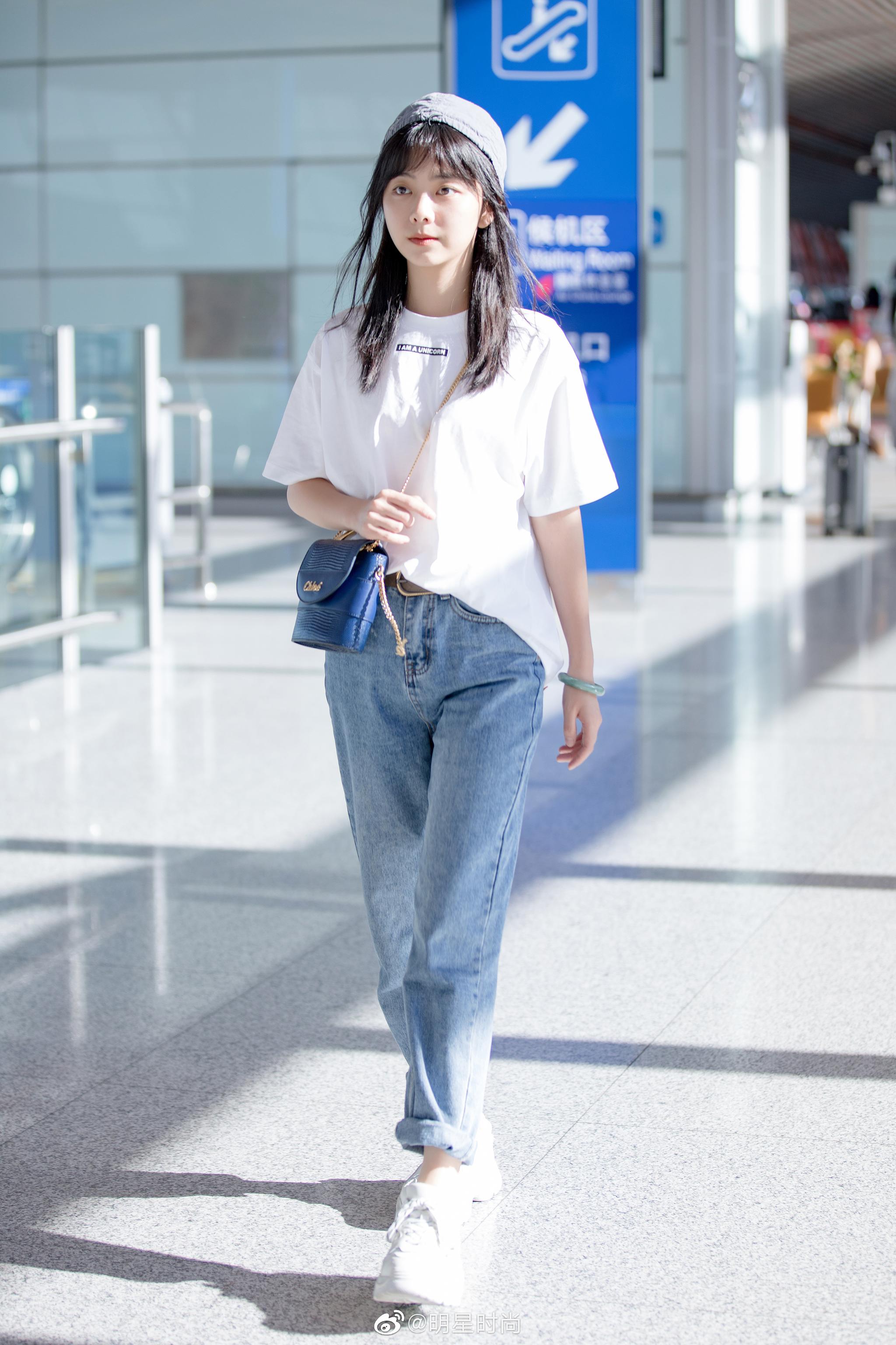 8月27日,谭松韵现身北京机场,burberry白t搭配卷边牛仔裤