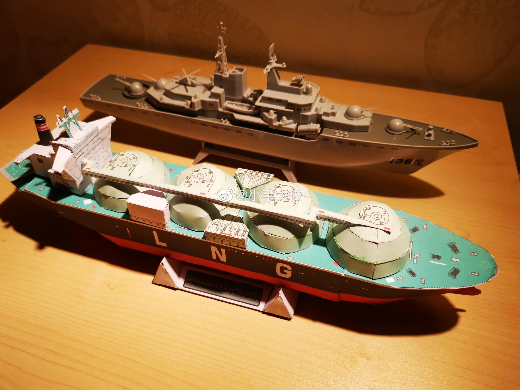 新闻播着阅兵实况,娃拿出来他自己做的纸模舰艇和航海模型来演练