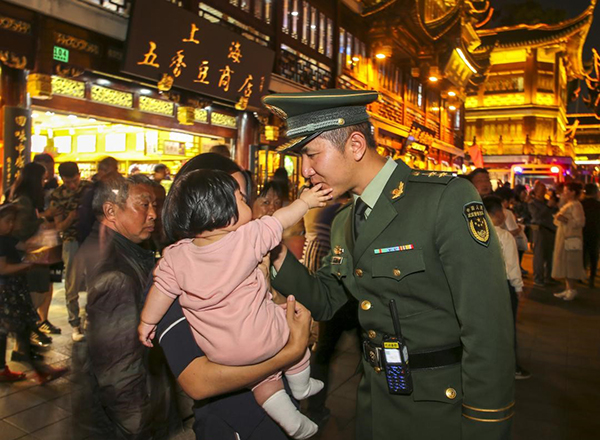  2019年5月3日，上海豫园，6个月大的孩子抚摸父亲武警徐照的脸。武警上海总队供图