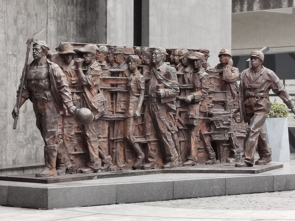 广州农民工博物馆门口有一组农民工形象雕塑.