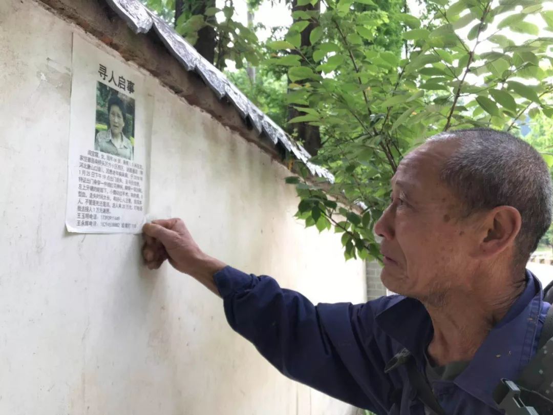 ▲5月9日，王玉明在张贴寻人启事。新京报记者 祖一飞 摄