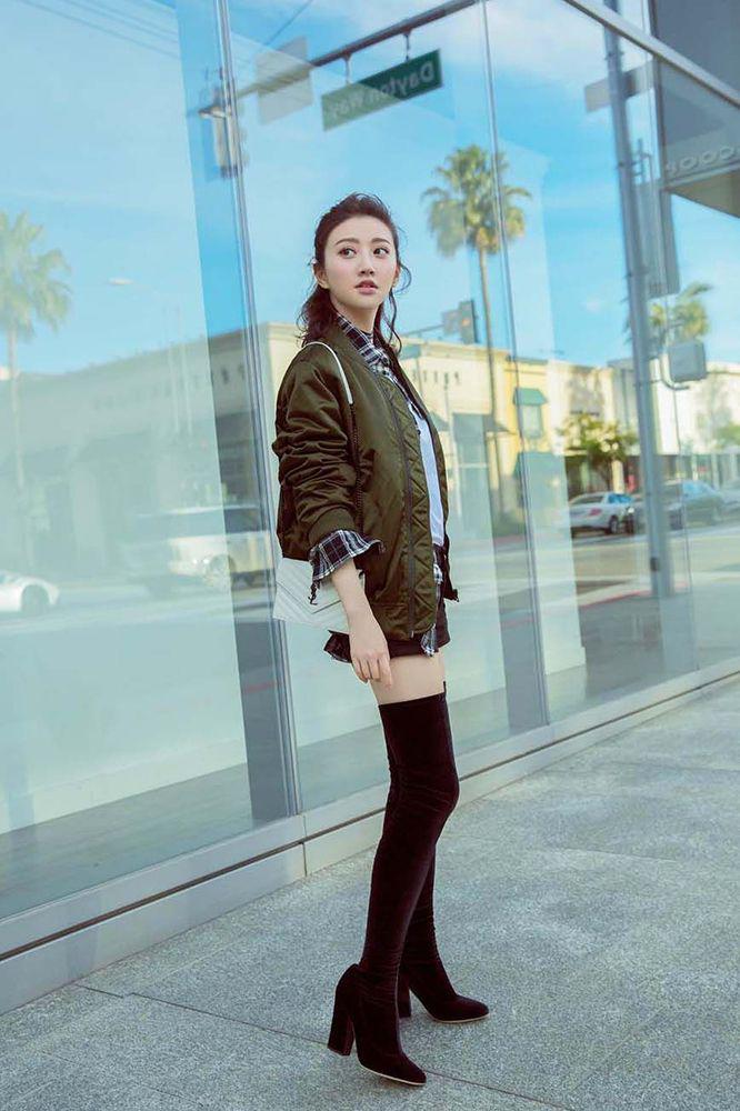 景甜现身街拍,穿一件短款机车皮衣,搭配一条蓝色牛仔紧身裤,脚踩一双