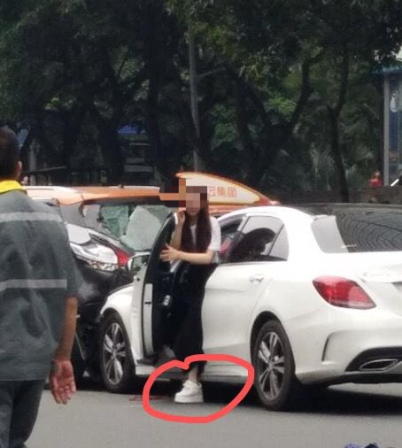 网传图片中，白色车辆驾驶位上一名长发女子打着电话下车。