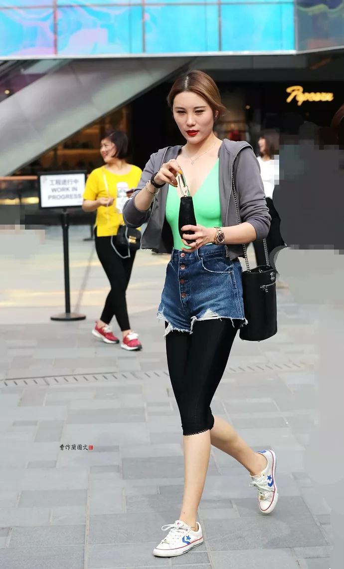 街拍:穿黑色五分打底裤加蓝色乞丐牛仔短裤的美女