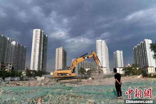 资料图:工人操作挖掘机在山西太原一商品房建设工地施工作业。中新社记者 韦亮 摄