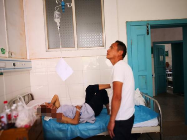 程正华的儿子在医院相顾他，他的身上多处烧伤。 甘明强 摄