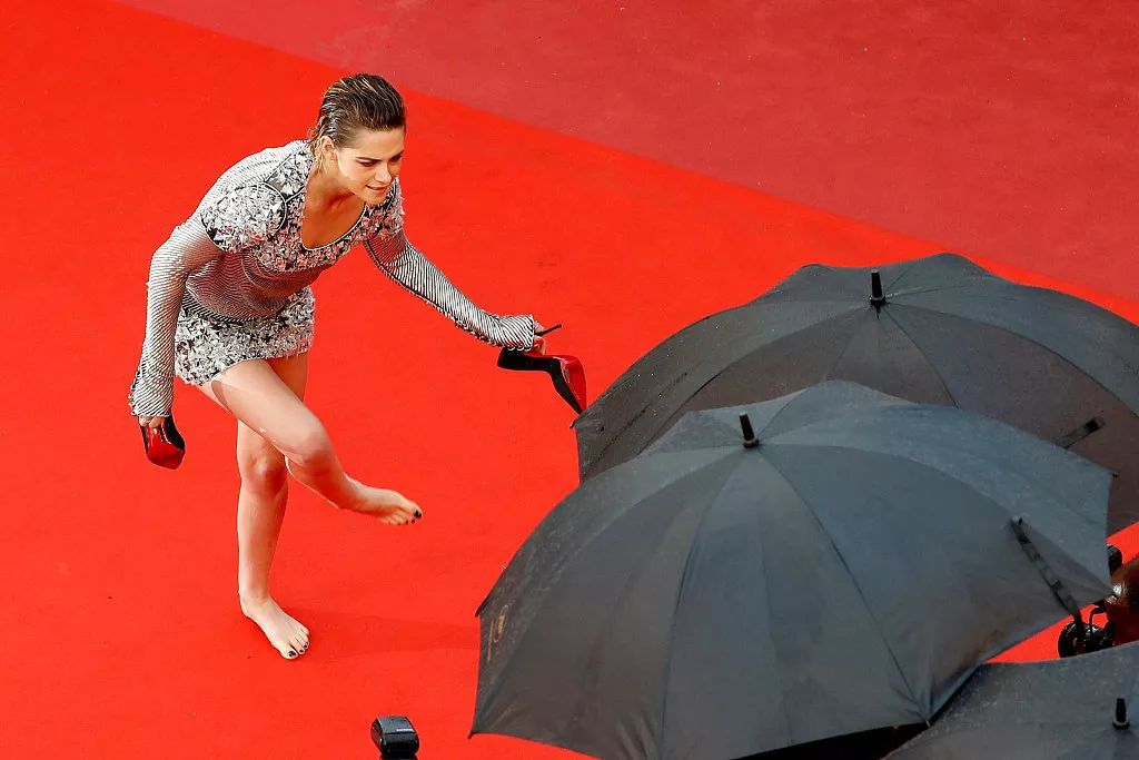 当地时间2018年5月14日，女演员克里斯汀·斯图尔特在第71届戛纳国际电影节红毯上脱下高跟鞋。/视觉中国