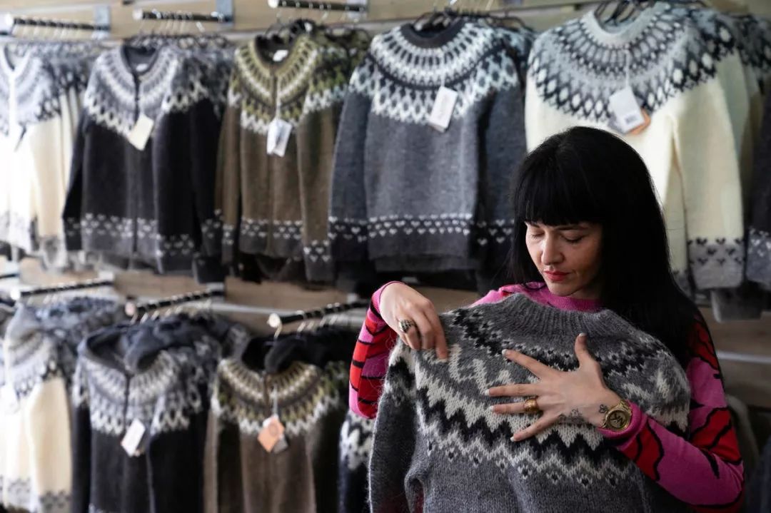 在冰岛首都雷克雅未克（Reykjavík）的一家商店，一名助理店员正在折叠冰岛花毛衣（图源：CBS）