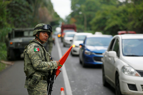 墨西哥军警6月14日在南部边境城市塔帕丘拉检查来往车辆（路透社）