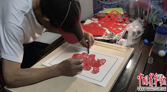 余希建在刻纸画。本版照片除署名外均为中国青年报·中青在线记者 马宇平/摄