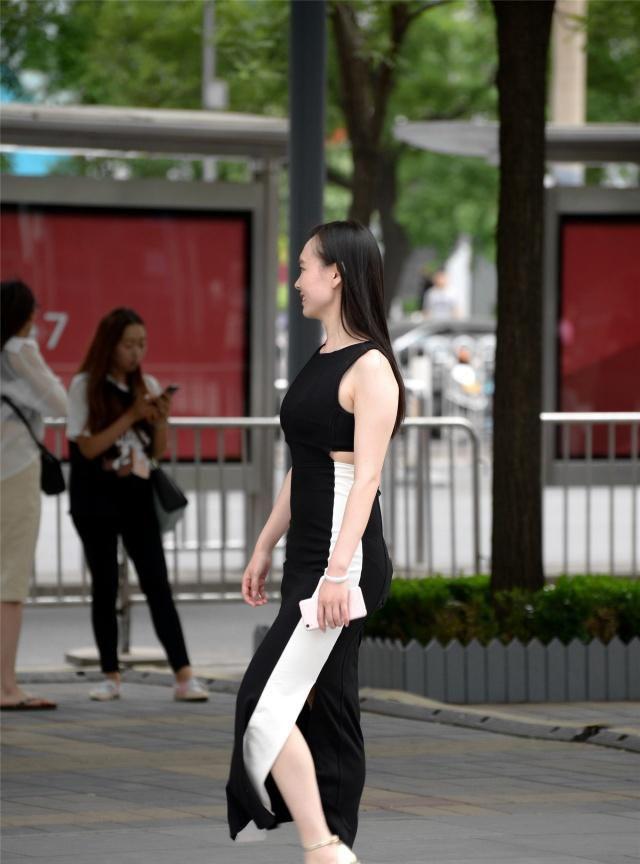 黑色连衣裙,侧面一条白色装饰,搭配出显身材的效果