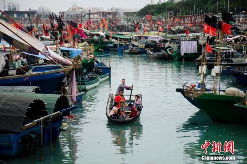资料图：广西北海电建渔港，渔民乘小艇上岸。中新社记者 翟李强 摄
