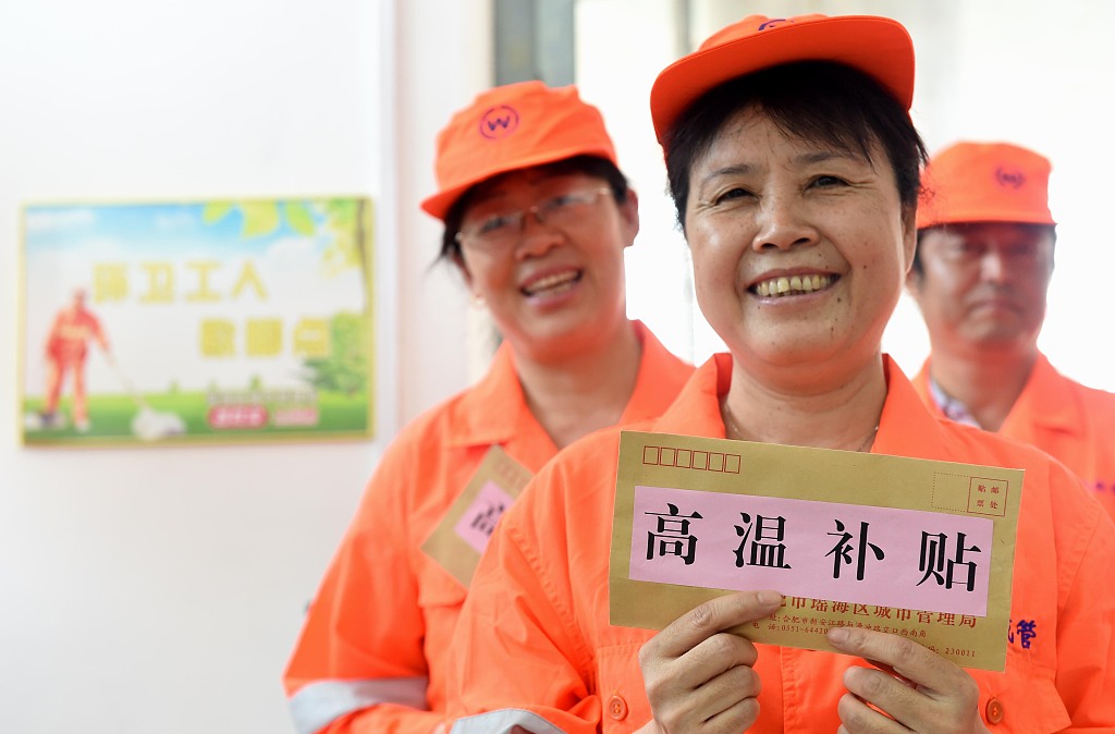 2016年7月29日，安徽省合肥市瑶海区，城管工作人员为环卫工人发放高温补贴和防暑降温医药包。图/视觉中国