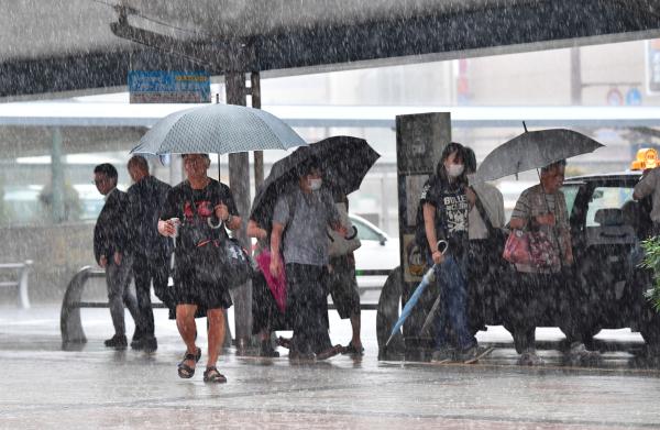 当地时间2019年7月3日，日本鹿儿岛，民众在雨中行走。 视觉中国 图