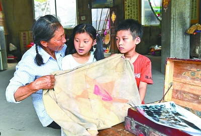 在湘江战役中收治受伤红军的村民的后代李青鸾在家里给孩子们讲述湘江战役的故事。新华社发