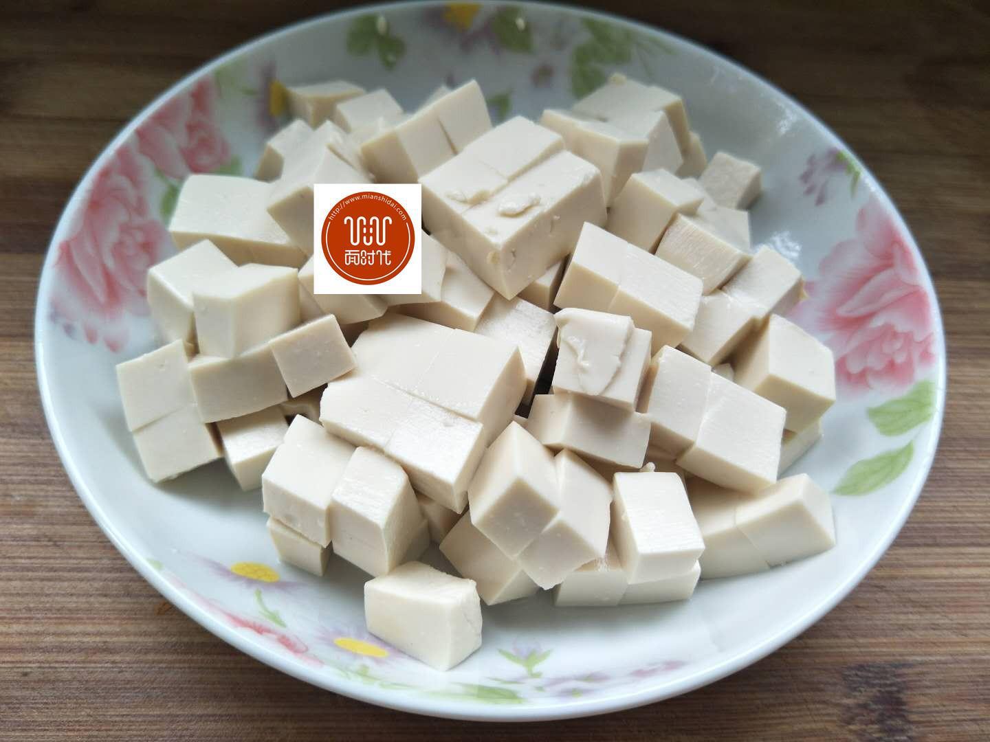 3,锅置火上,倒入清水烧开,将嫩豆腐放进锅里,焯水.