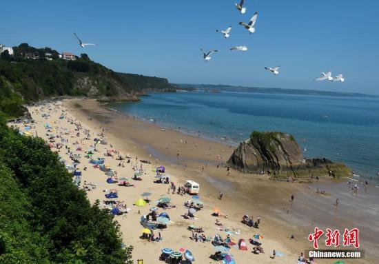 当地时间2019年7月23日,英国威尔士,当地迎高温天气,民众到海滩享受休闲时光。